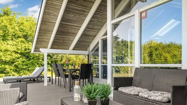An outdoor deck with wicker furniture, a table with drinks, and potted plants. - "Kai" - 400m from the sea by Interhome (Sydals)