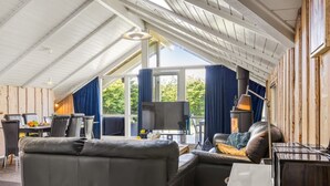 A cozy room with a black leather sofa, a television, and a fireplace. - "Kai" - 400m from the sea by Interhome (Sydals)