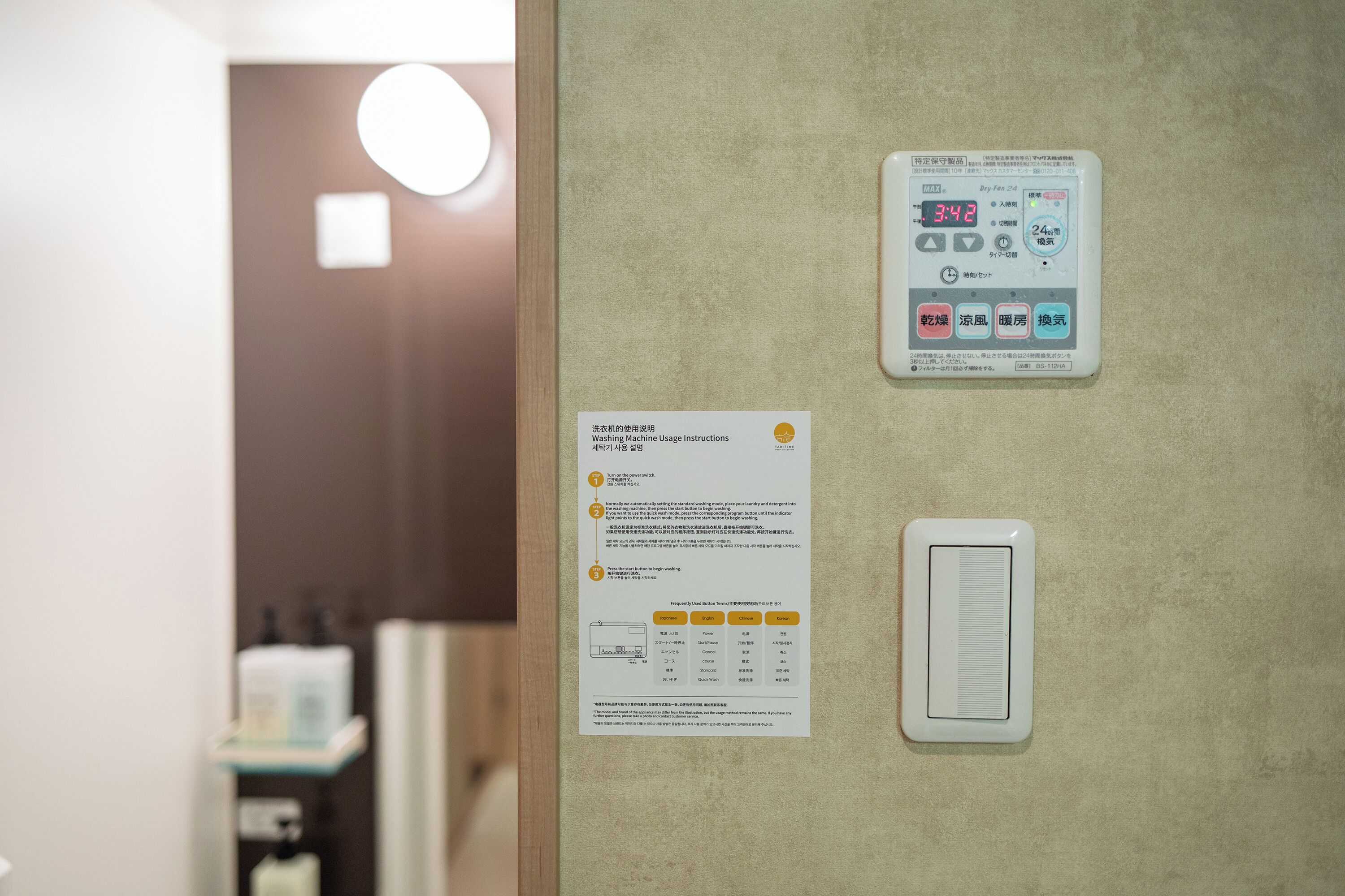 A wall with a digital display showing 3:42, a paper with usage instructions, and a ventilation unit.