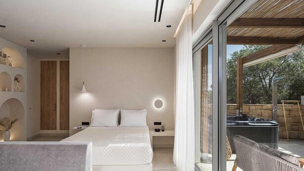 Une chambre à coucher moderne avec un grand lit, un balcon fermé par des baies vitrées et un design minimaliste.