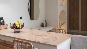 Une cuisine moderne dotée d’un éclairage suspendu, d’un îlot central et d’un coin salon avec un banc rembourré.
