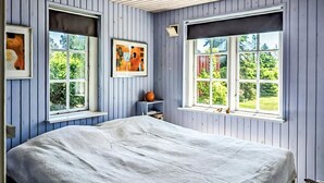 A bedroom with a bed, two windows, and a small shelf with a globe. - Gorgeous home in Væggerløse with WiFi (Væggerløse)