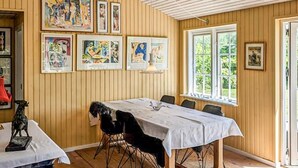A dining area with a long table, chairs, and framed artwork on the walls. - Gorgeous home in Væggerløse with WiFi (Væggerløse)