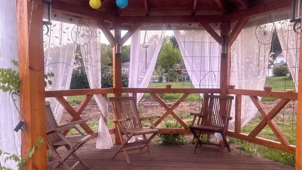Eine Holzterrasse mit Stühlen und einer Pergola.