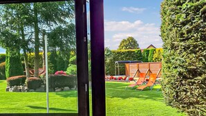 A well-maintained garden with a lawn, a wooden play structure, and neatly trimmed hedges. - Nice home in Cieciorka with heated swimming pool (Cieciorka)