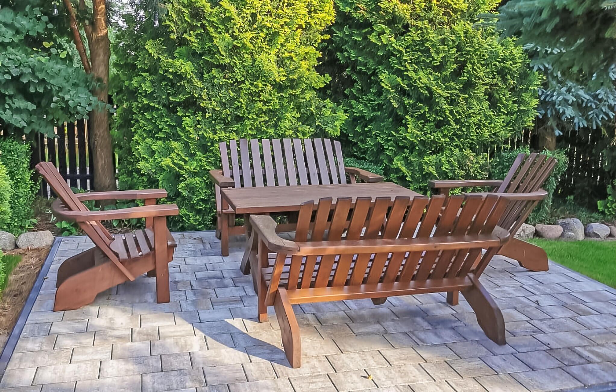 A wooden outdoor patio with a table and four chairs.