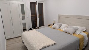 A bedroom with a bed, a nightstand, a wardrobe, and a mirror. - Bright apartment with terrace & sea view (IB)