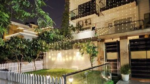 Un bâtiment moderne doté d’un jardin bien entretenu, d’une clôture blanche en bois et d’une entrée sécurisée par un portail.