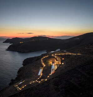 A coastal resort with a winding road leading to a building with multiple rooms. - Olen Syros (Syros)