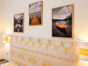 A hotel room with a bed, a curtain with a golden pattern, and three framed pictures on the wall. - Private YELLOW Apartment at Palma de Sols – No Shared Living Spaces (Sant'antioco)