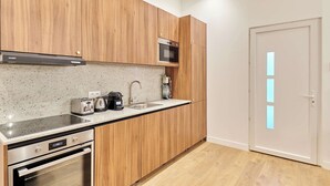 Une cuisine moderne avec des meubles en bois, des appareils en acier inoxydable et un plan de travail en granit.