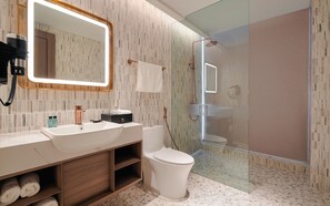 Ein modernes Badezimmer mit großem Spiegel, Waschbecken, Toilette und einer Duschkabine.