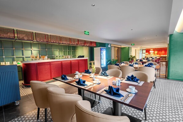 A modern dining area with a long table set for a meal, surrounded by comfortable chairs. - Le Carré Hue (Hue)