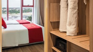 A hotel room with a bed, a wardrobe, and a view of the city. - Le Carré Hue (Hue)