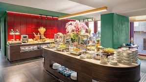 A buffet setup with various food items and a decorative centerpiece. - Le Carré Hue (Hue)