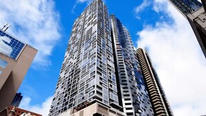 Un immeuble de grande hauteur doté d’une architecture moderne, caractérisé par de nombreuses fenêtres et des balcons.
