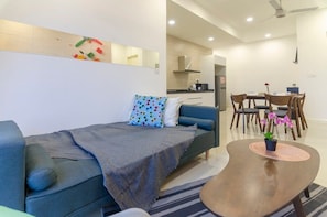 Un salon moderne comprenant un canapé, une table basse et un coin repas avec des chaises et une table.