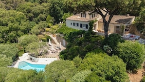 Vue aérienne d’une villa dotée d’une piscine, entourée d’une végétation luxuriante.