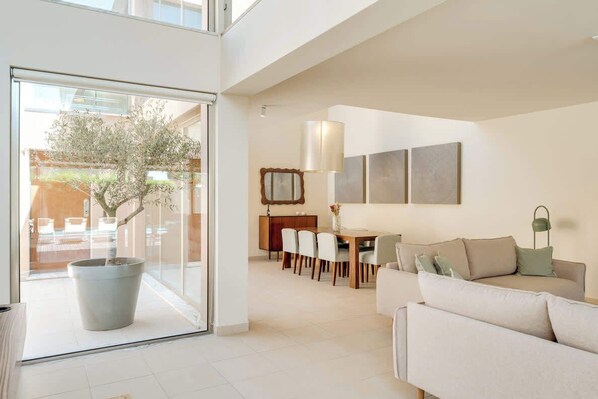 A spacious living area with a dining table, sofa, and a large potted plant. - 2BR Villa w/ Private Pool | Salgados | DA’Home (Guia)