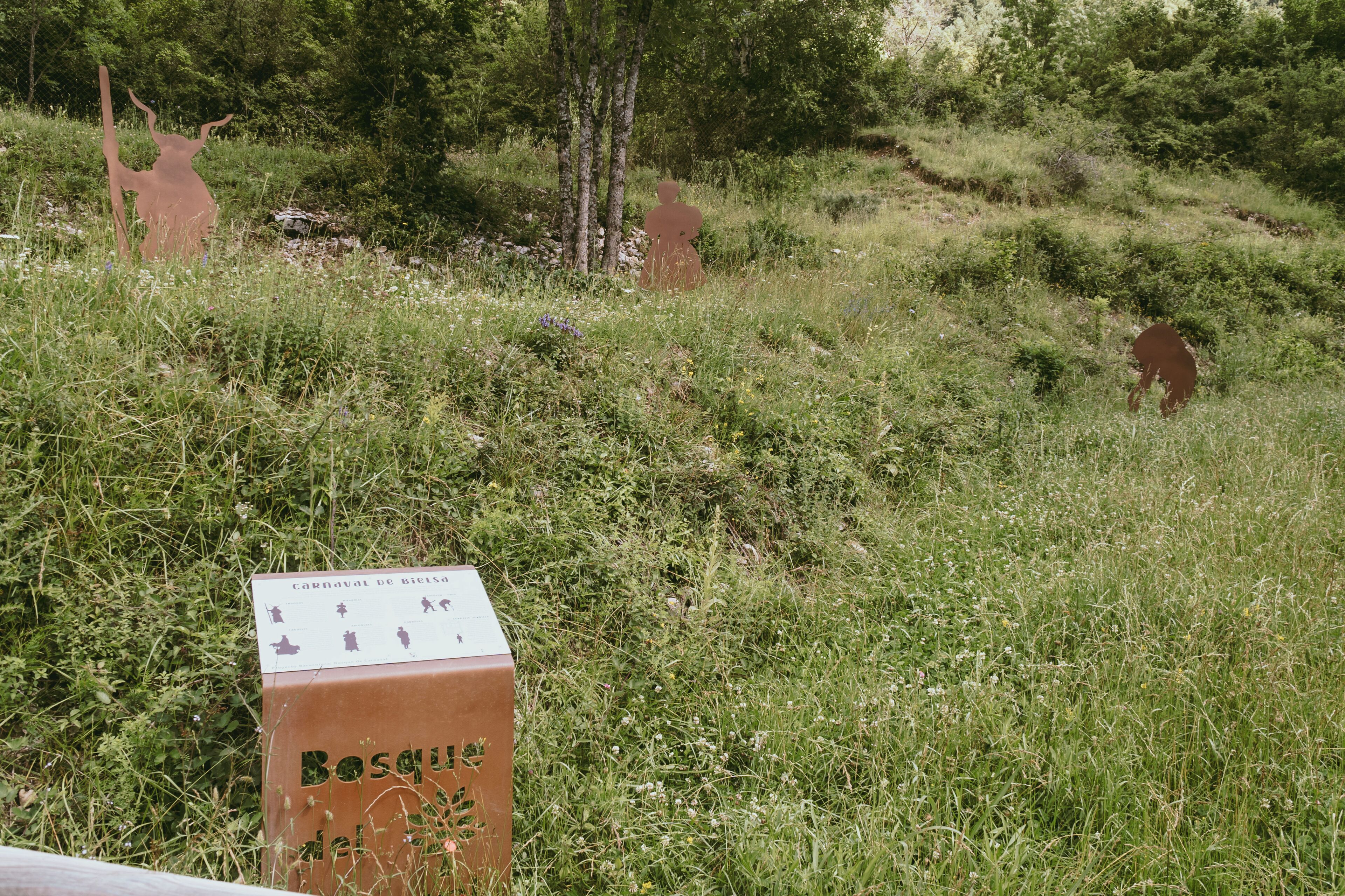 A rustic wooden box with a sign indicating 'Carnaval de Ricisa' and 'Bosque de la Candelaria'.