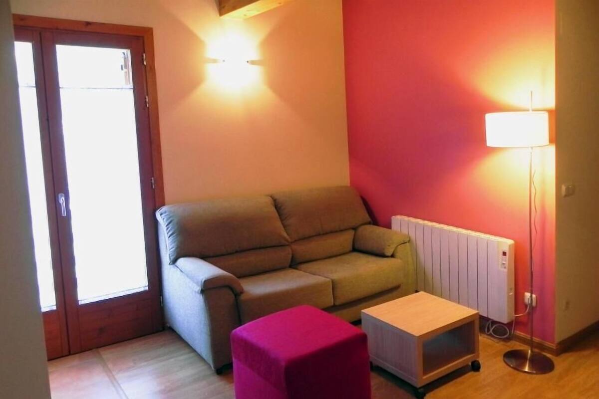 A small living room with a sofa, a small table, and a lamp.