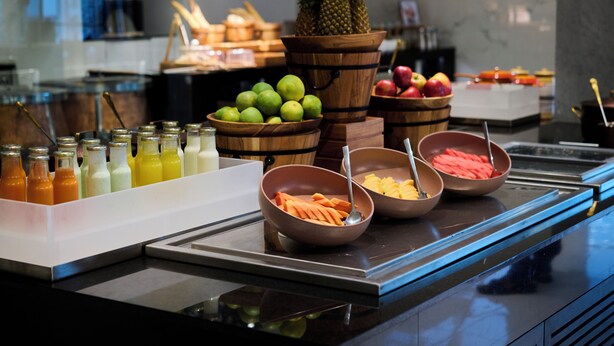 Een buffet met diverse soorten fruit, groenten en drankjes.
