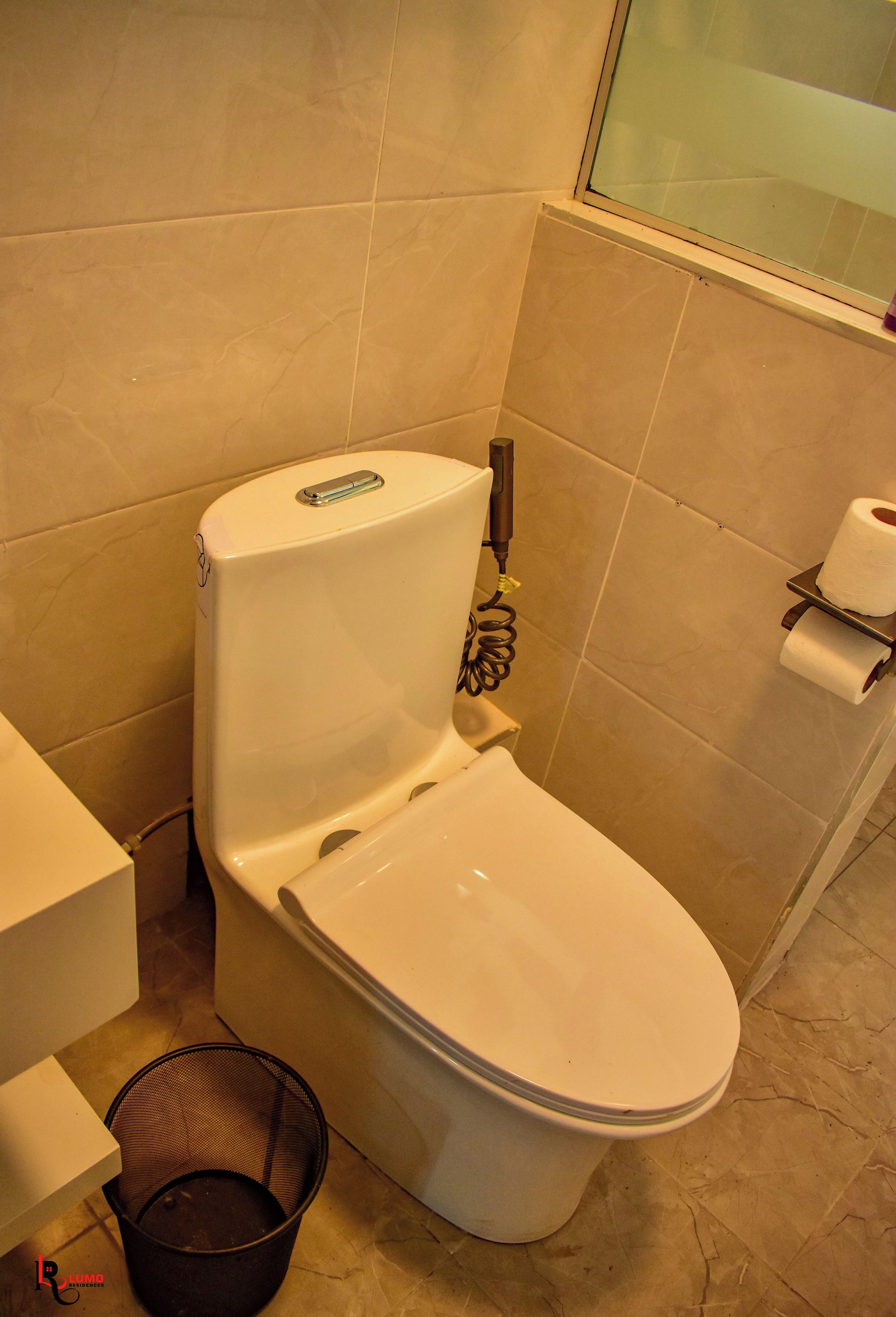 Un bagno con il water, un bidet, un portasciugamani e un cestino.