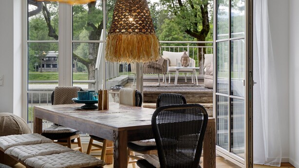 A dining area with a wooden table, chairs, and a hanging light fixture. - Apartment 'Lieblingsplatz' with Mountain View, Private Terrace and Wi-Fi (Bad Tölz)