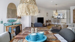 A dining area with a wooden table, chairs, and a hanging light fixture. - Apartment 'Lieblingsplatz' with Mountain View, Private Terrace and Wi-Fi (Bad Tölz)
