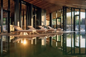 Una piscina techada, sillones reclinables de piscina