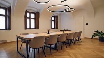 Una sala de conferencias con una larga mesa, varias sillas e iluminación moderna.
