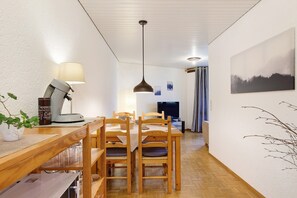 Uma sala de jantar com móveis de madeira, uma luminária e um quadro na parede.