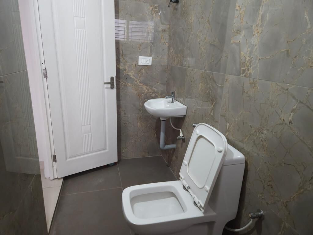Ein Badezimmer mit Toilette, Waschbecken und einer Tür.