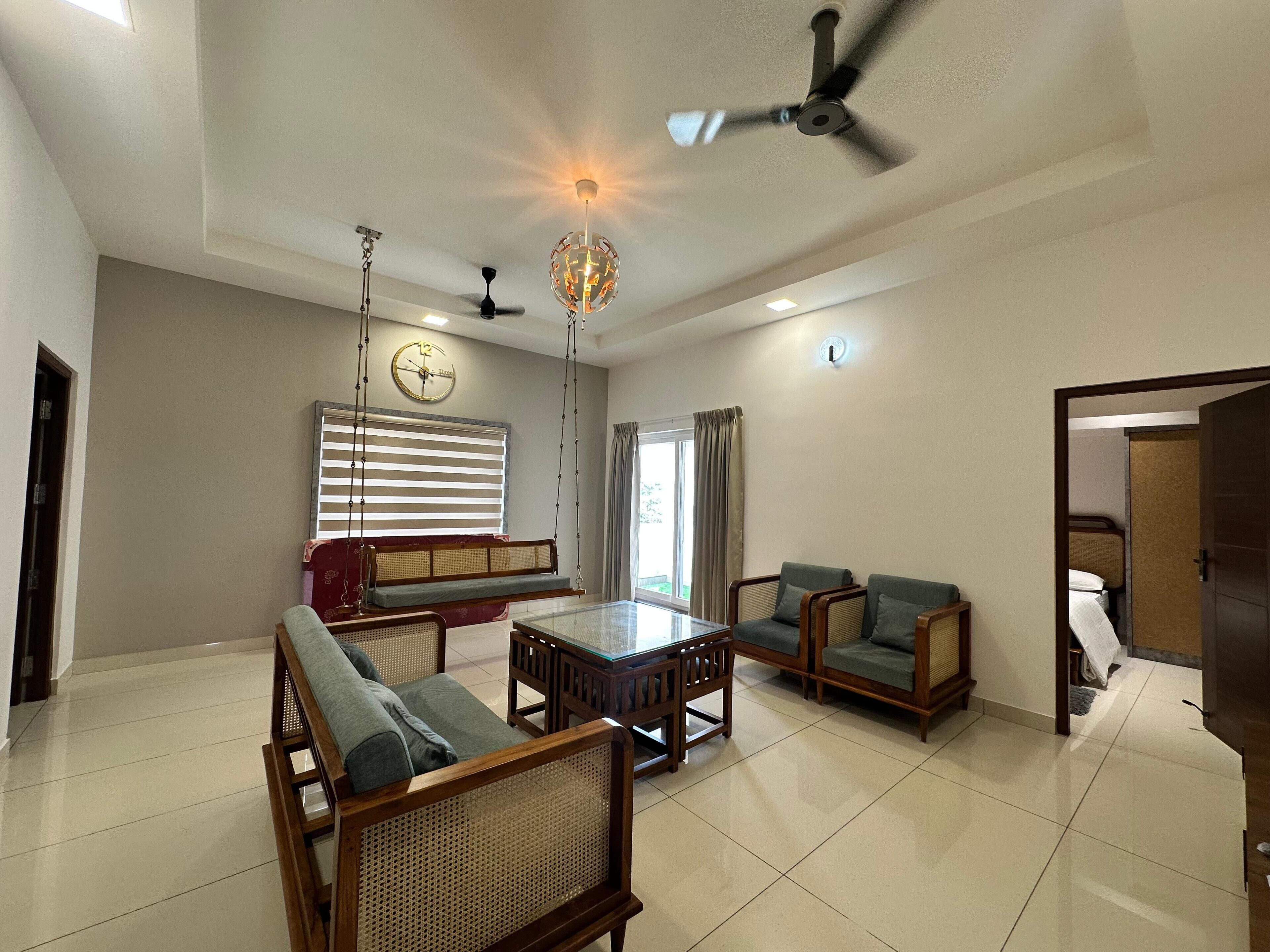 A spacious living room with a sofa set, a coffee table, and a ceiling fan.