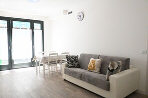 A living room with a sofa, chairs, a table, and a clock on the wall. - SE190 - Senigallia, renovated one-bedroom apartment with air conditioning (Senigallia)