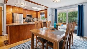 A modern kitchen with wooden cabinets, stainless steel appliances, and a central island.