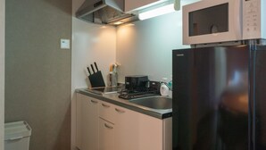 A compact kitchen with a microwave, refrigerator, sink, and a coffee maker. - New open F Maison Kishinosato 301 (Osaka)
