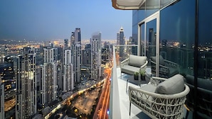 A high-rise balcony with a city view, modern furniture, and a clear night sky. - KeyRock Living - Skyline at Paramount (Dubai)