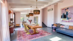 A spacious dining area with a long wooden table, multiple chairs, and hanging chandeliers. - Villa Belvedere Condor - L - with Pool (Alassio)