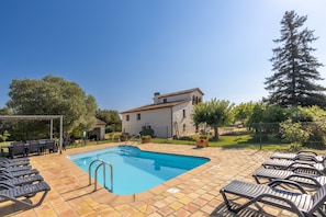 A swimming pool with lounge chairs, a pergola, and a building with a tiled roof. - Holiday Home 'Simon' with Mountain Views, Private Pool and Wi-Fi (San Dalmay)
