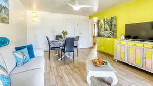 A living room with a sofa, coffee table, and a dining area with chairs and a table. - Comfortable apartment with terrace and direct pool access (La Possession)