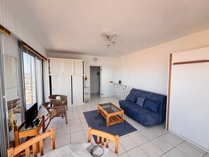 Een woonkamer met een bank, een salontafel en een televisie.
