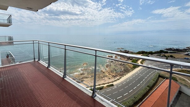 A balcony with a view of the sea, a road, and rocky terrain. - Studio sea view and balcony, 10th floor (Les Sables-d'Olonne)