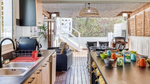 A modern kitchen with a wooden countertop, a sink, and a dining area with a table set for four.