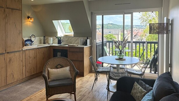 Una cocina moderna con comedor, ventanas amplias y vistas al campo.