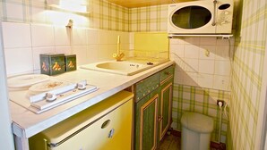 A compact kitchen with a microwave, sink, and a small refrigerator. - Studio for 4 people at the foot of the slopes near shops (Chamrousse)