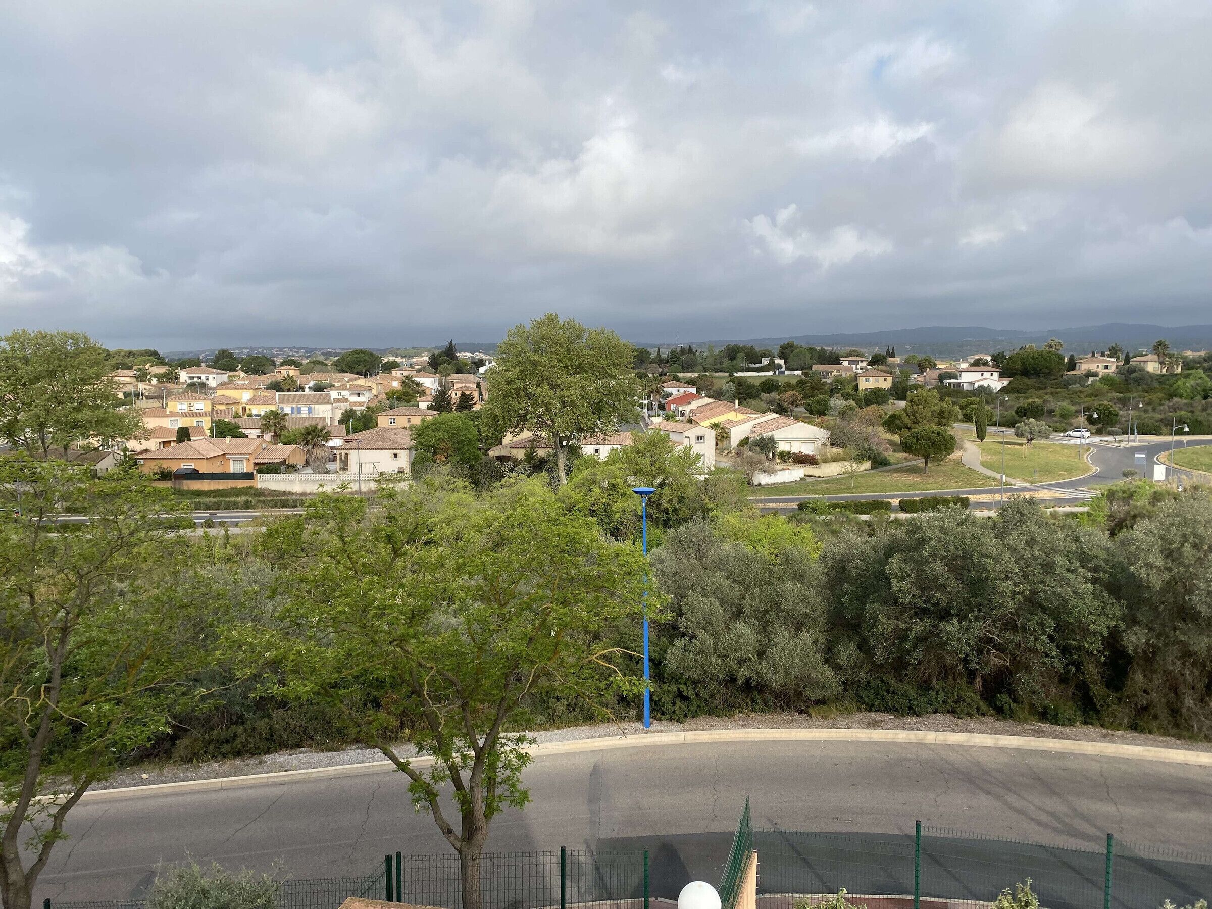 Un barrio residencial con casas, árboles y una calle.