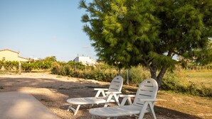 Outdoor seating with a tree and a building in the background. - Apartment in Holiday Home "Casa Sorrapa" (Deltebre)