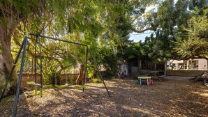 A backyard with a swing set, a picnic table, and a small play area. - Apartment in Holiday Home "Casa Sorrapa" (Deltebre)