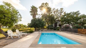 A rectangular swimming pool with a concrete deck, surrounded by trees and a wooden fence. - Apartment in Holiday Home "Casa Sorrapa" (Deltebre)